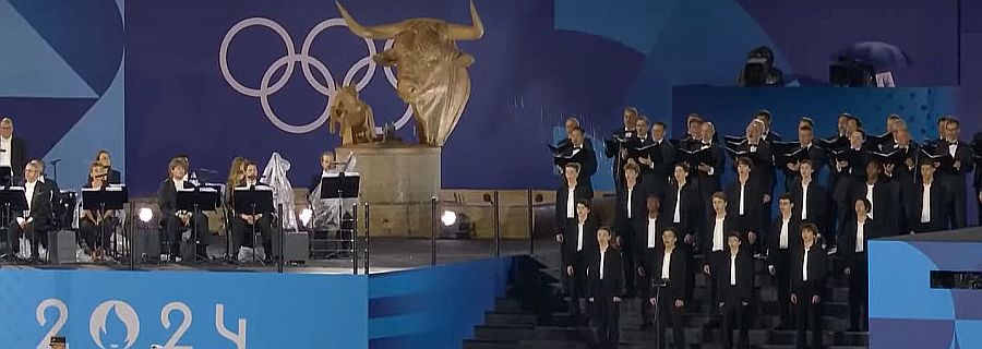A zászlófelvonás után a kórus az ötkarika és az „aranyborjú” mellett énekli az olimpia himnuszát